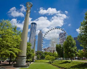 Centennial park showing pillars and a ferris wheel inside a giant green park